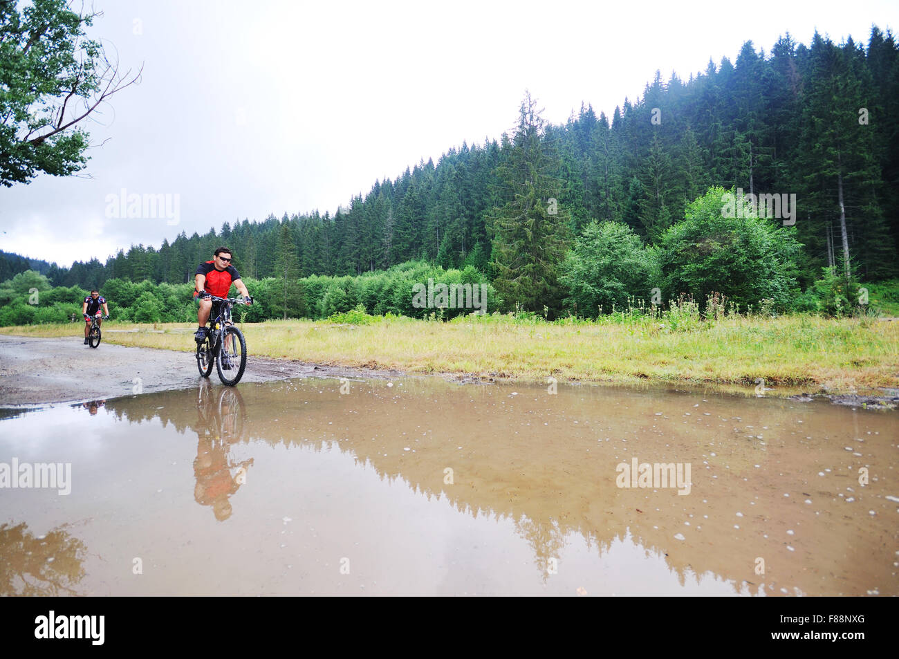 young man drive mountain bike over water river Stock Photo Alamy