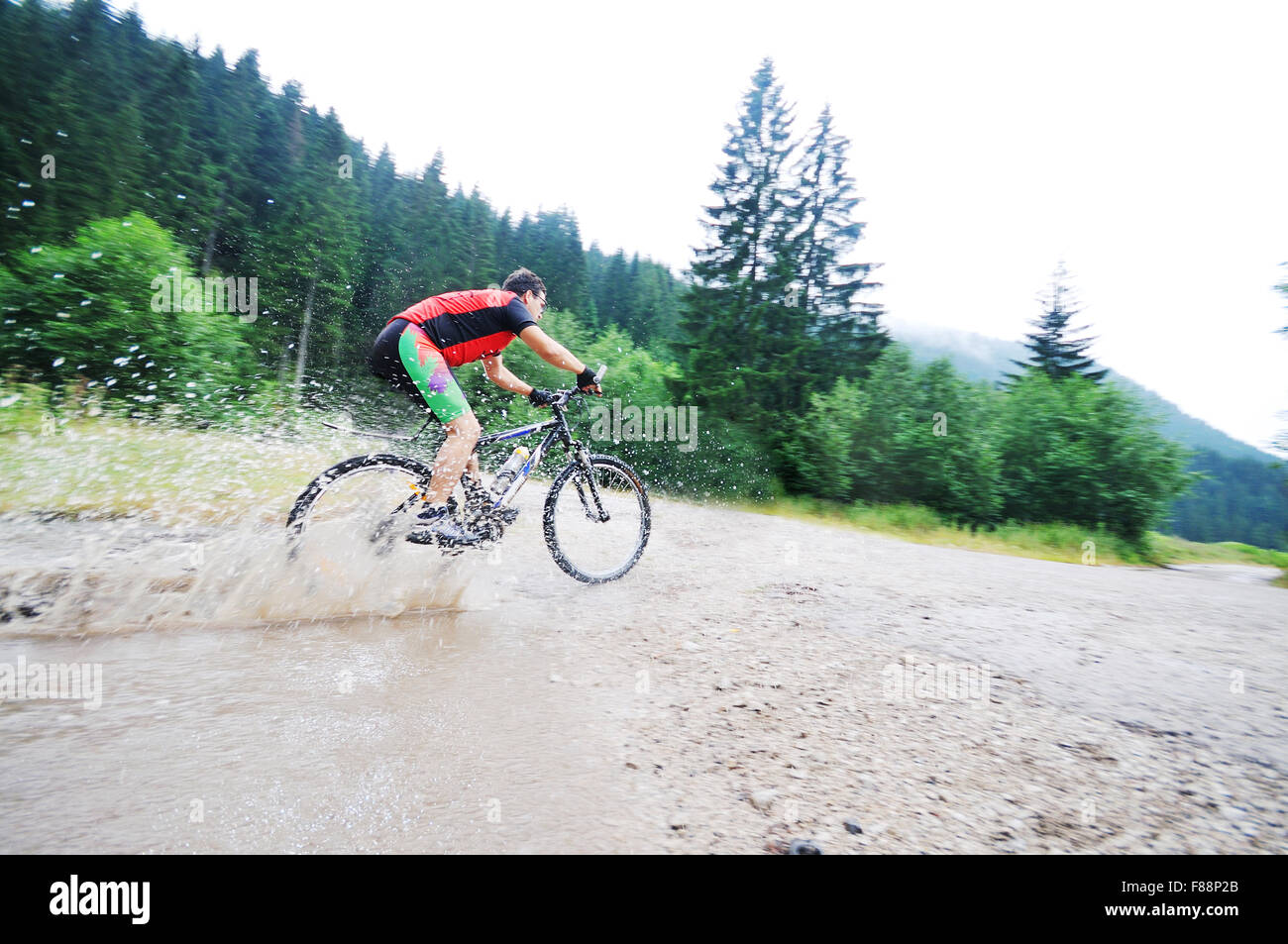 young man drive mountain bike over water river Stock Photo Alamy