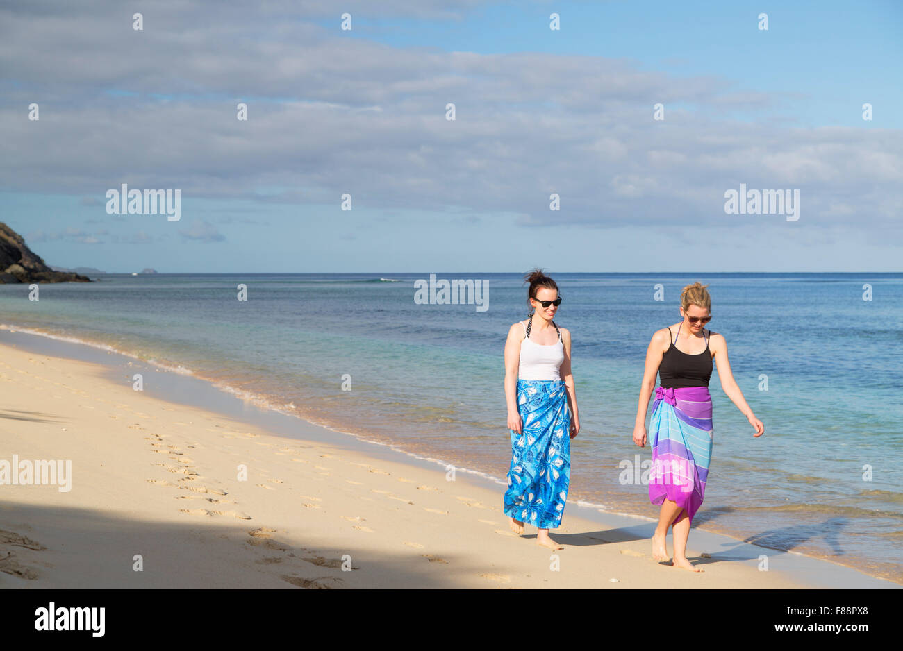 Women walking on beach at Octopus Resort, Waya Island, Yasawa Islands, Fiji (MR) Stock Photo