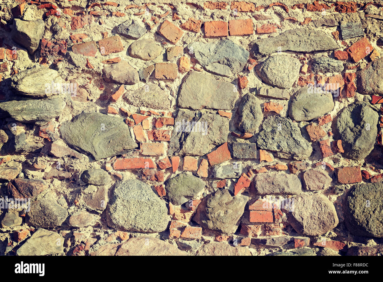Retro toned old stone and brick wall, background or texture. Stock Photo