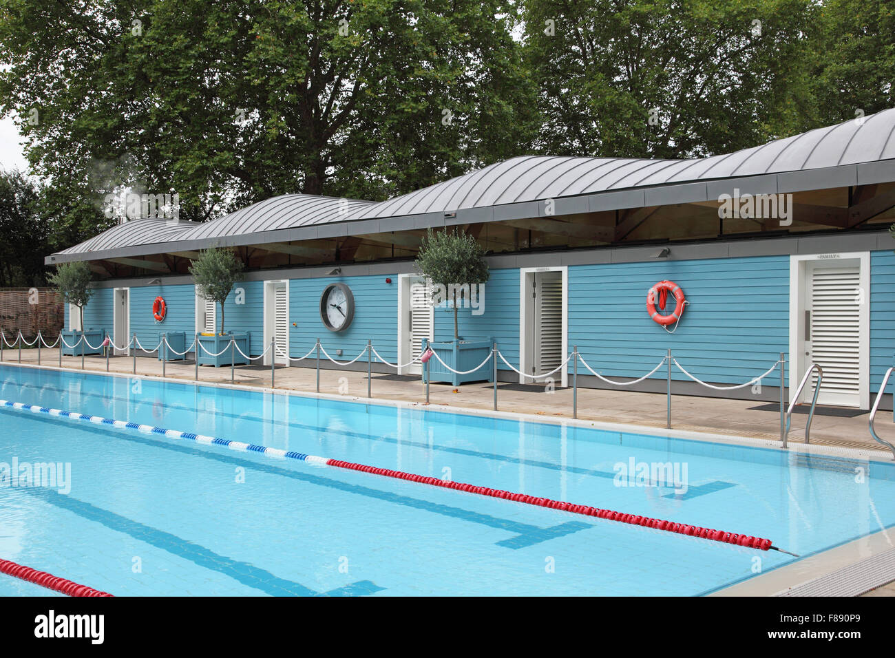 A private open-air swimming pool with a distinctive zinc-roofed changing room block. Stock Photo