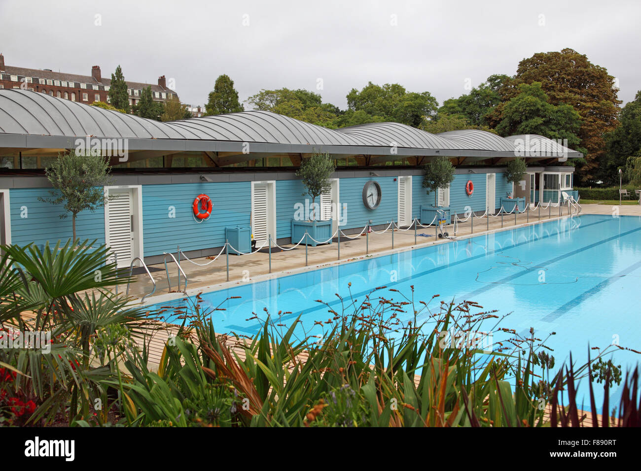 The open air swimming pool close to the River Thames at London's Hurlingham club. Shows new changing room block. Stock Photo