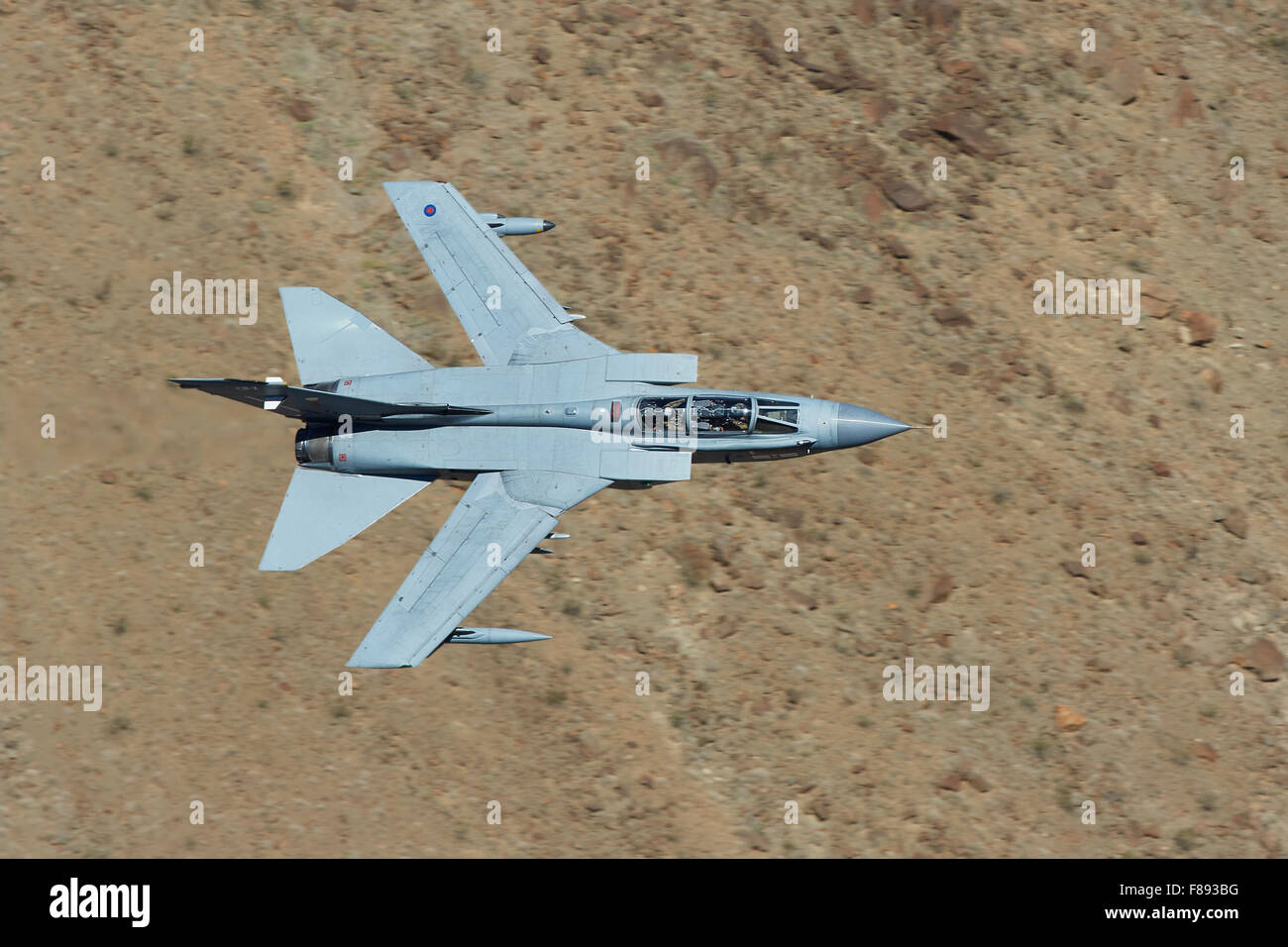 Royal Air Force Tornado GR4 Jet Fighter Flying At Very Low Level Through A Desert Valley. Stock Photo