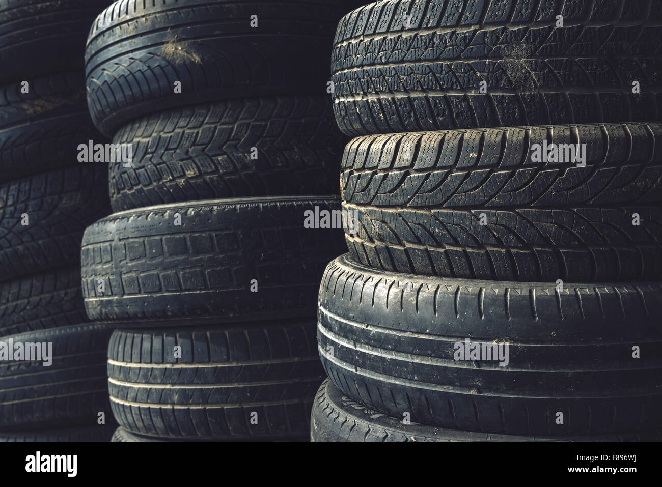 Column stack of old used car tires in secondary car parts shop garage