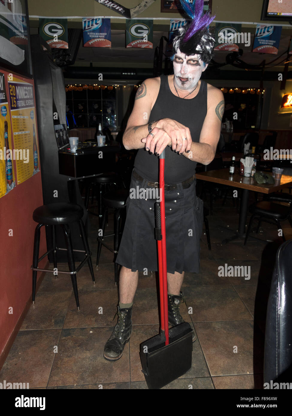 Scary but friendly Halloween white faced 'The Joker' cleanup man at Nezzy's Sports Bar & Grill. Cumberland Wisconsin WI USA Stock Photo