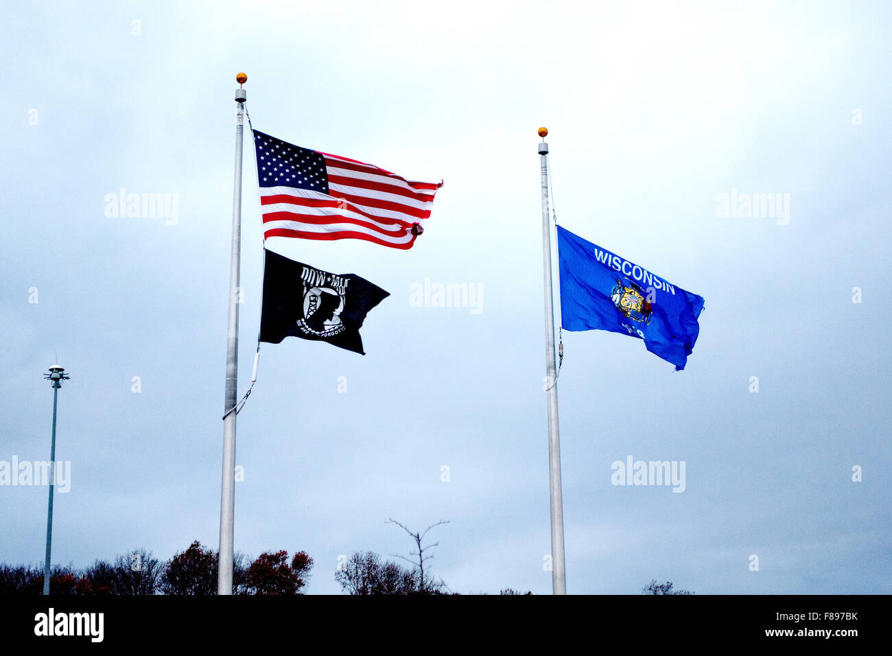 Wisconsin State, POW-MIA and American USA flags blowing in the wind. Freeway 94 Wisconsin WI USA Stock Photo