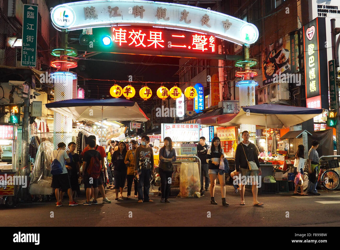 Entrance to Linjiang Street (Tonghua) Night Market in Taipei with pedestrians crossing the road Stock Photo