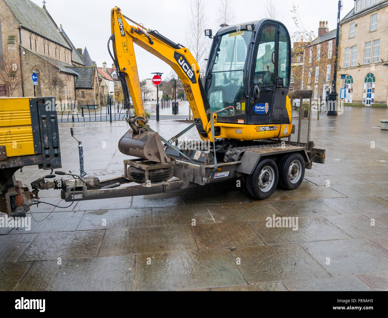 JCB 8018 Mini Digger Excavator in a town centre on a railer for transportation Stock Photo
