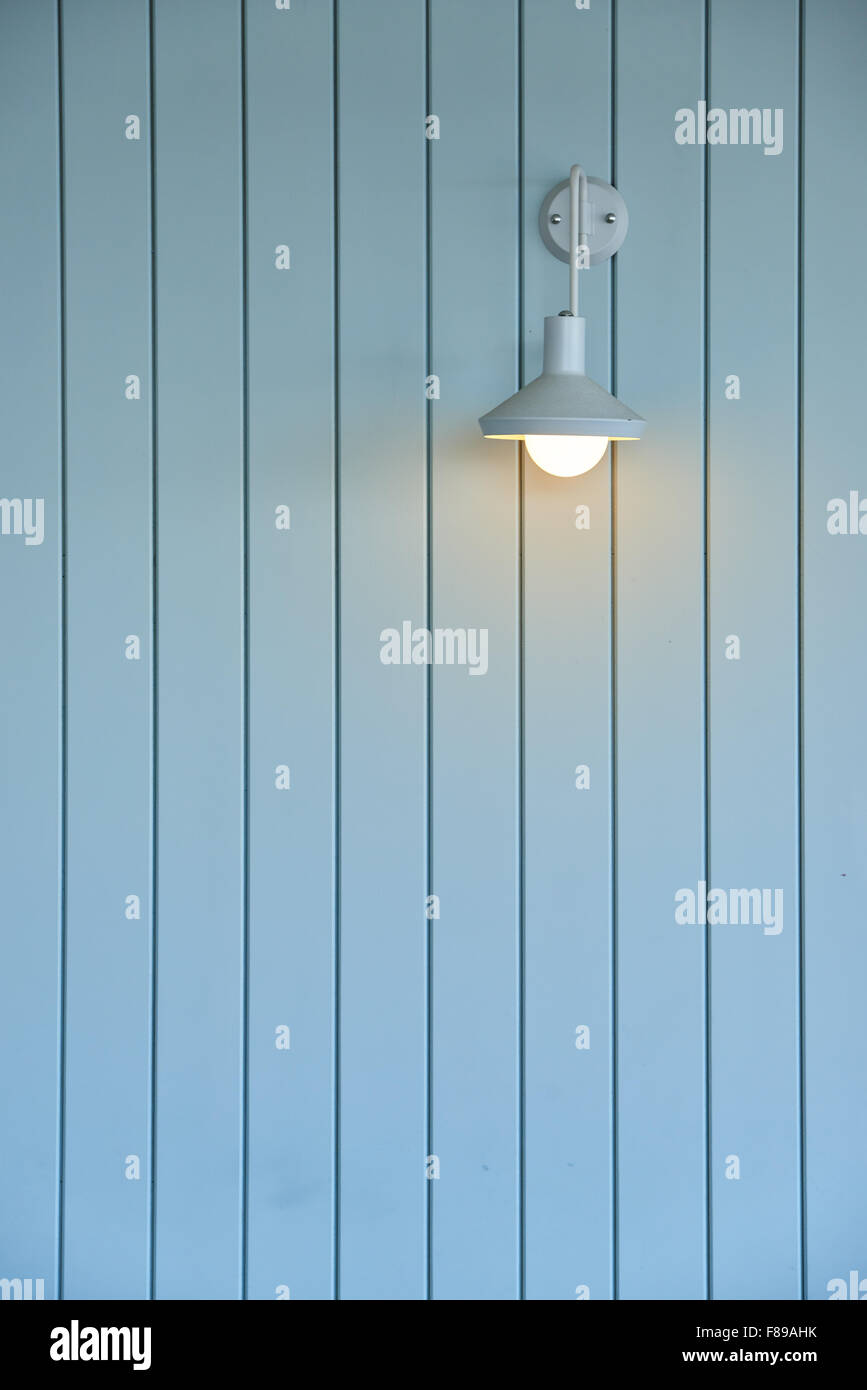 wall made from wood panel painted blue and white lamp on the wall Stock Photo