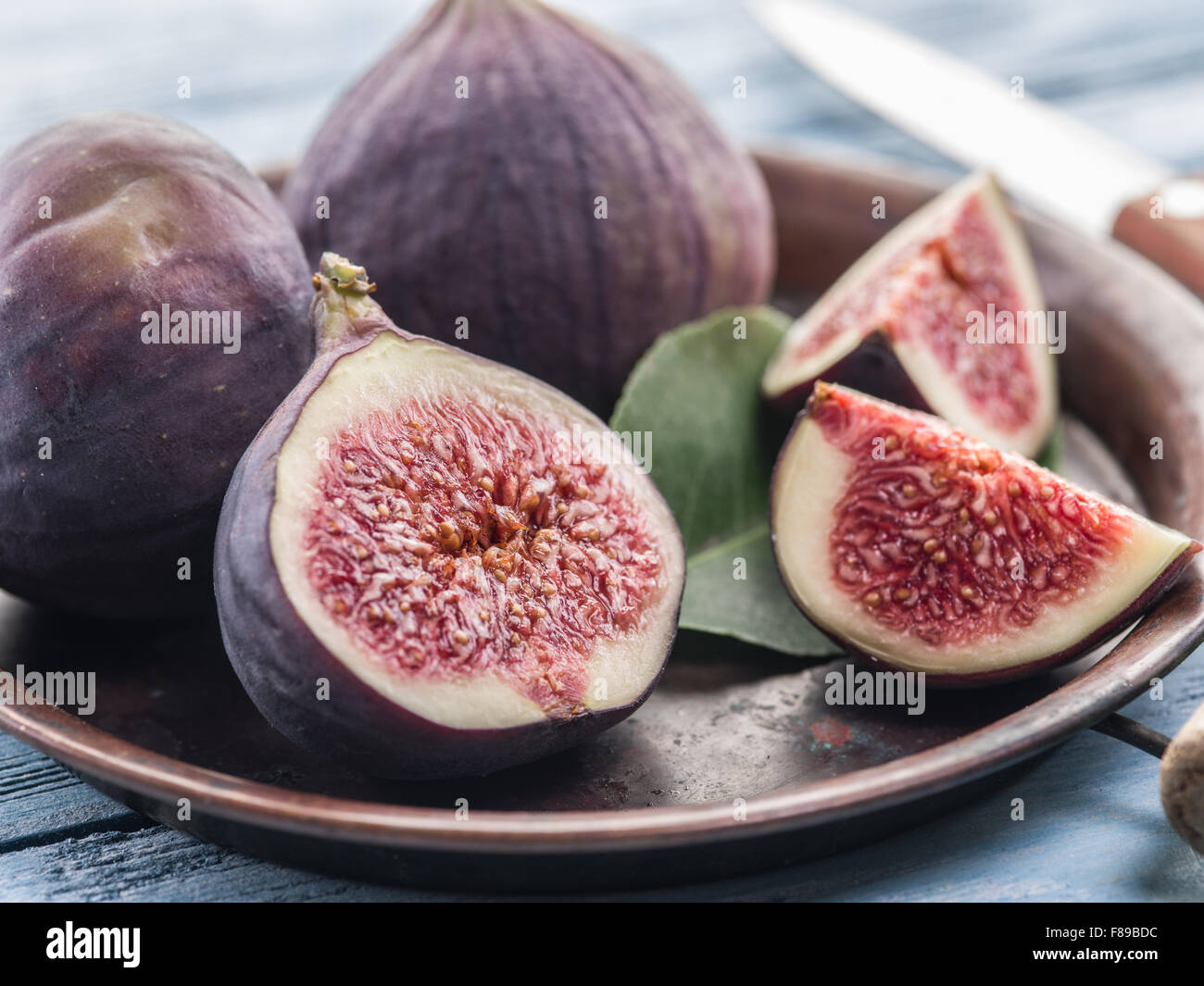 Ripe fig fruits on in the old tray on the wooden table. Stock Photo