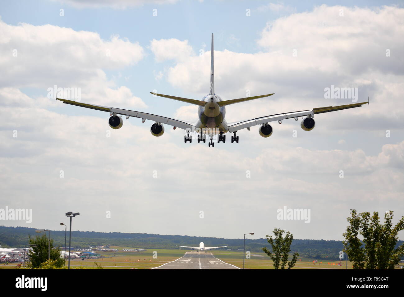 An Airbus A380 landing at Farnborough Air Show 2014 while an Airbus A350 takes off Stock Photo