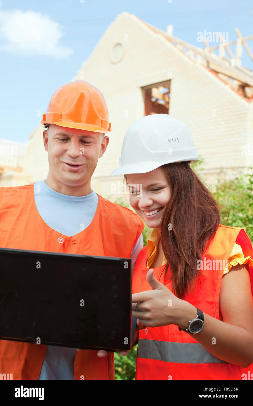 two happy builders in hardhat works on the building site Stock Photo ...