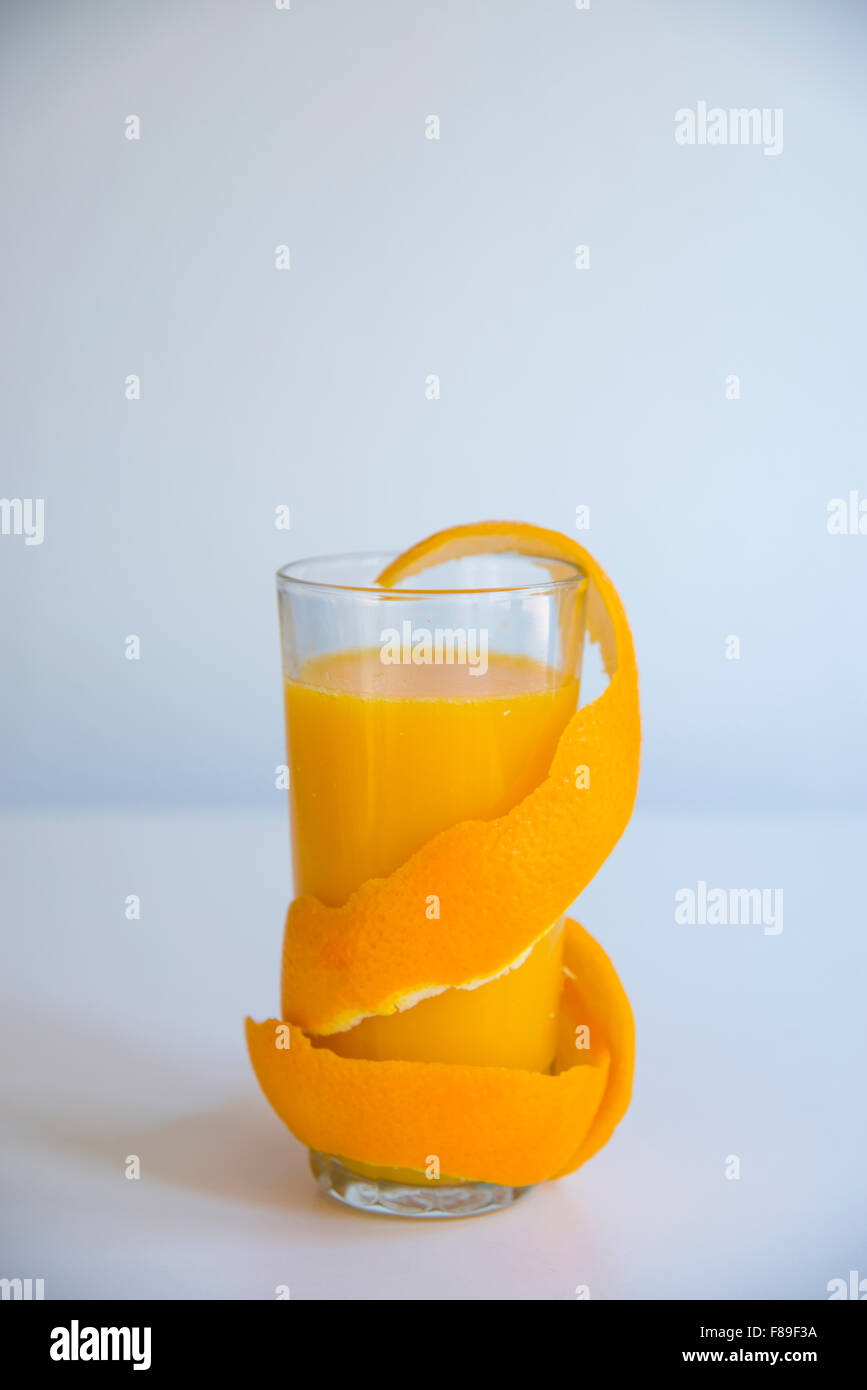 Glass of orange juice with the peel coiled around the glass. Stock Photo