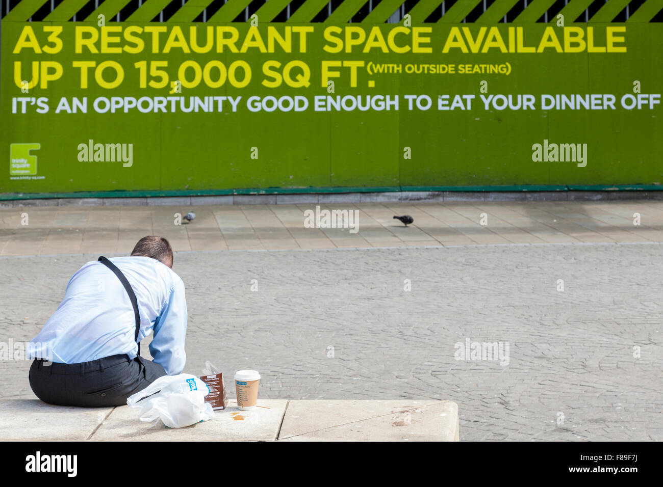 Food and drink humour. Man with take away food and drink sitting outside next to a restaurant space available sign, Nottingham, England, UK Stock Photo