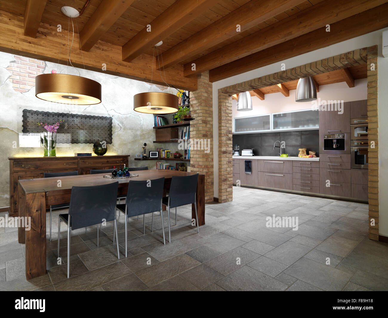 foreground of dining room in the living room overlooking on the kitchen with tile floor and wood ceiling Stock Photo