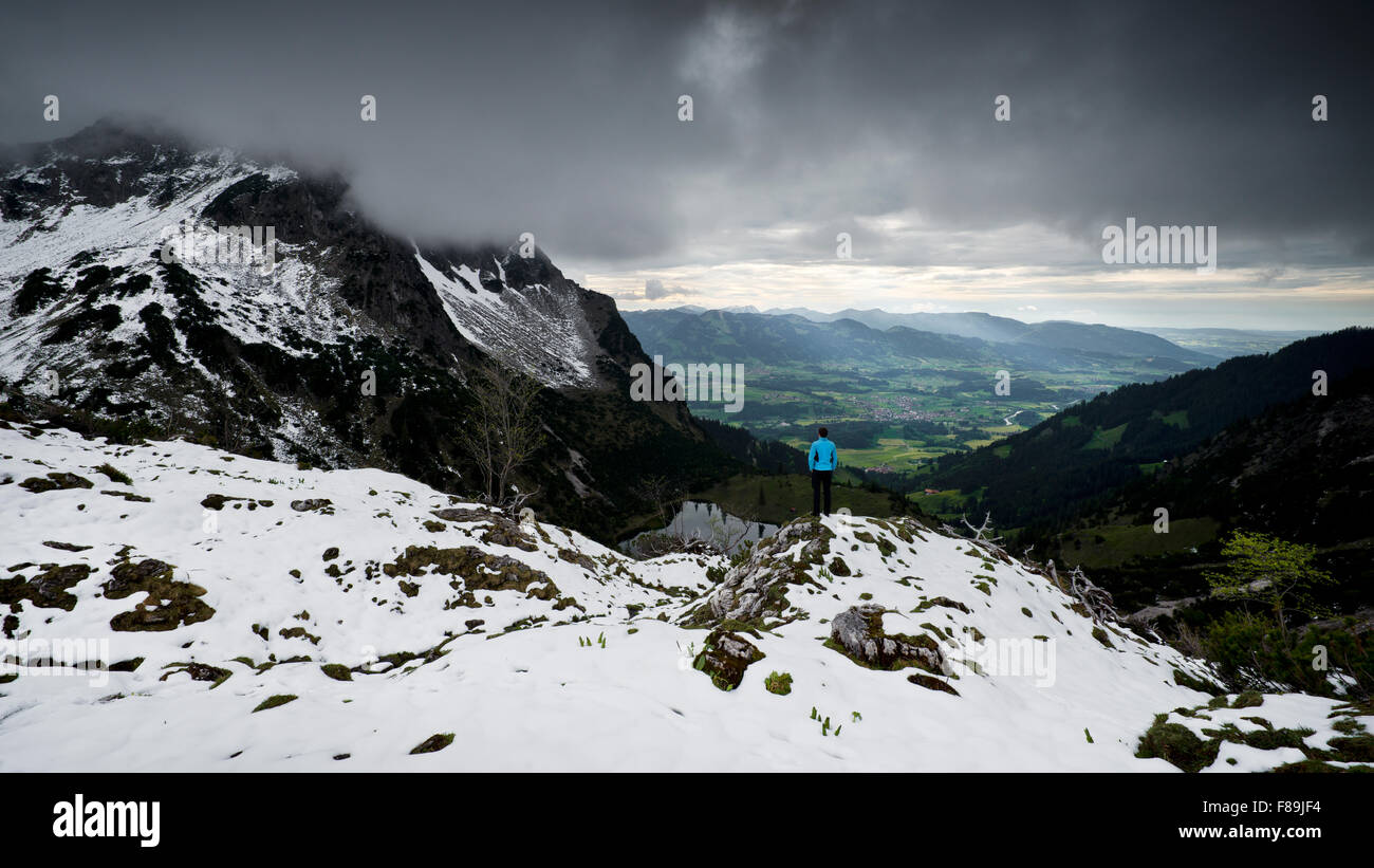 Hiker looking from a mountain into the valley, Alps, Bavaria, Germany Stock Photo