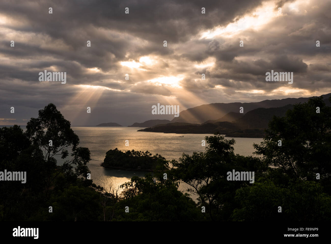 Sun rays breaking through the clouds at Ilhabela, Brazil Stock Photo