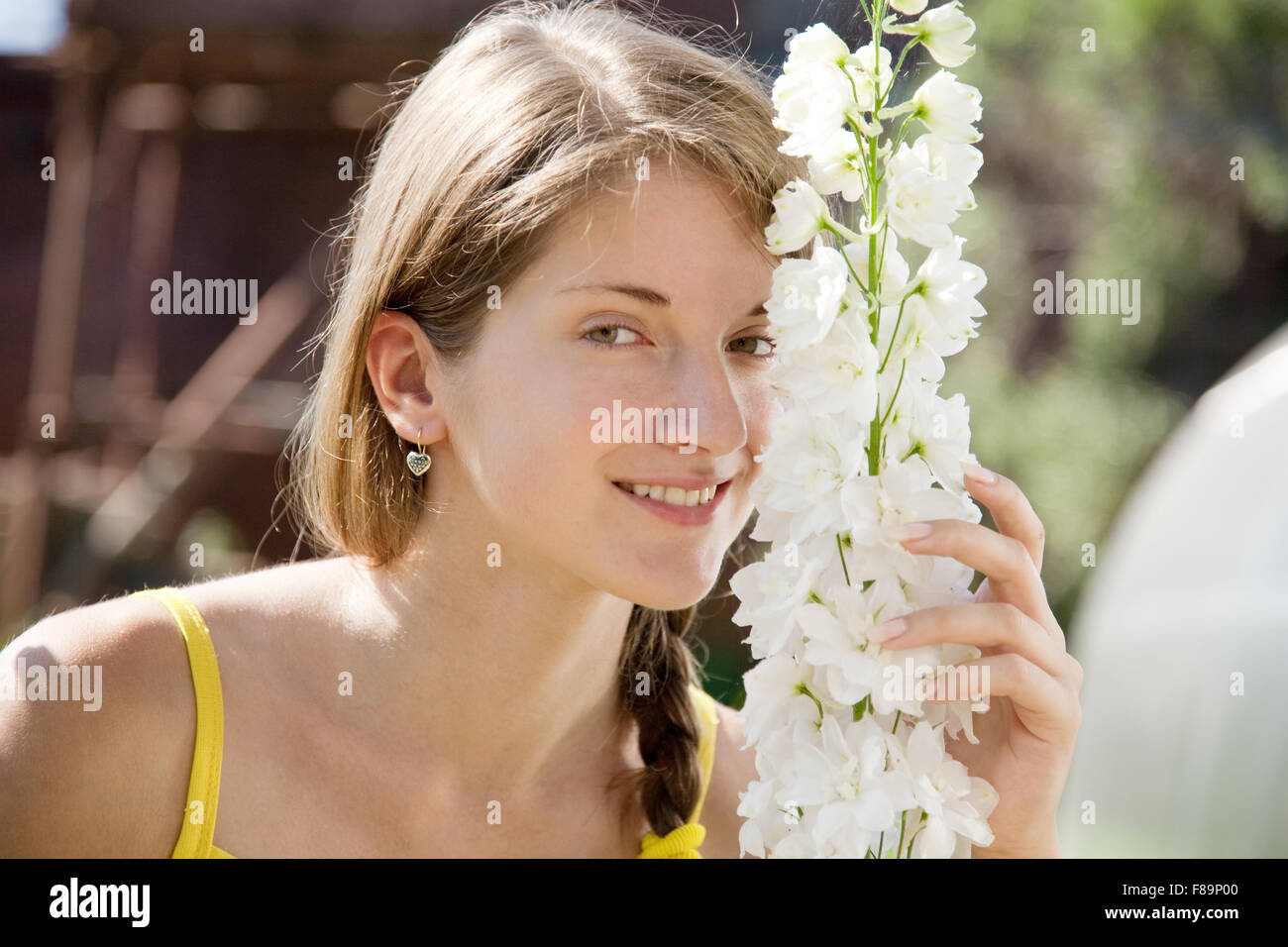 Young woman with  delphinium at her garden Stock Photo