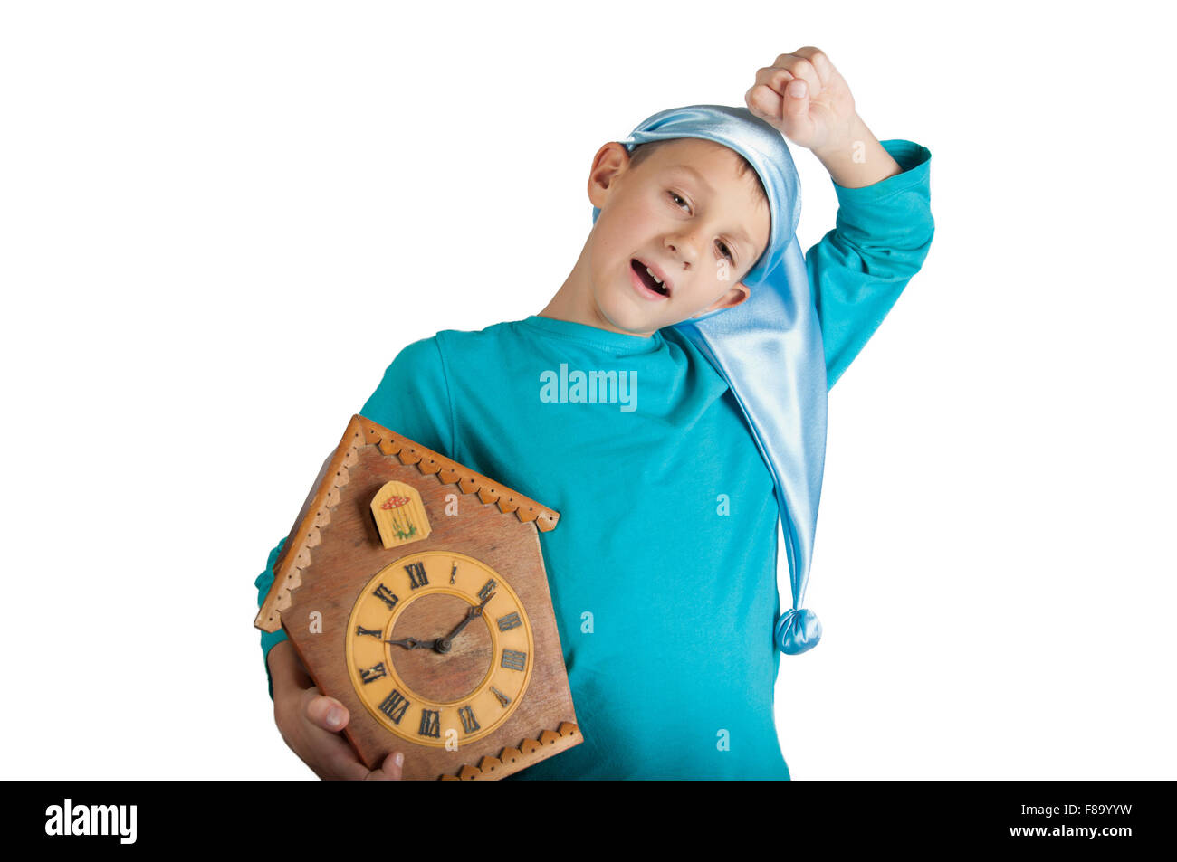 Cute boy in blue pajamas and sleeping hat holding clock and stretching
