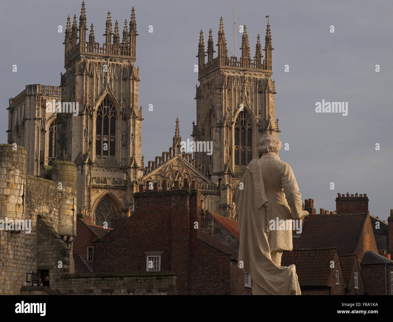 York Minster seen over the rooftops from Exhibition Square with the statue of artist William Etty in the foreground. Stock Photo