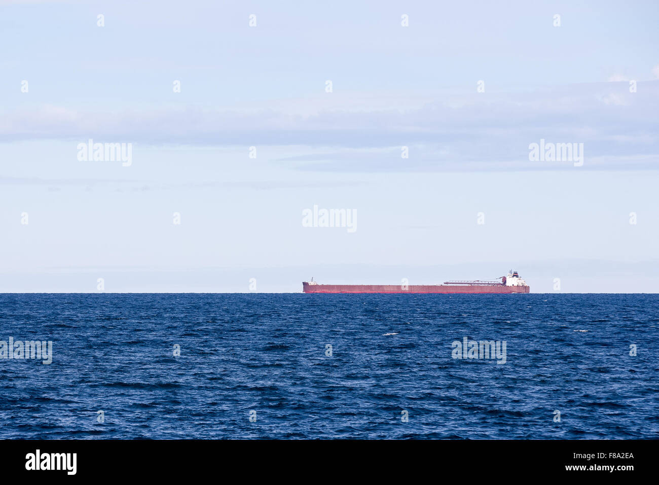Great Lakes ore boat on the horizon and copy space in the sky.  Horizon is at the one-third line to allow ample room for copy. Stock Photo