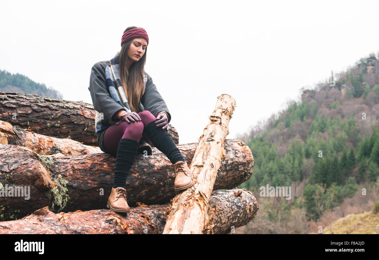 Young woman on wood logs Stock Photo - Alamy