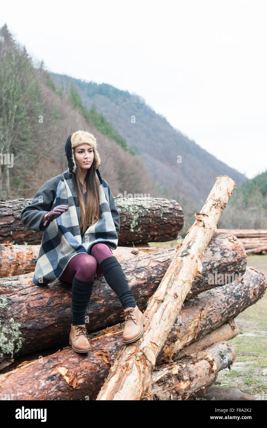 Young woman on wood logs Stock Photo - Alamy