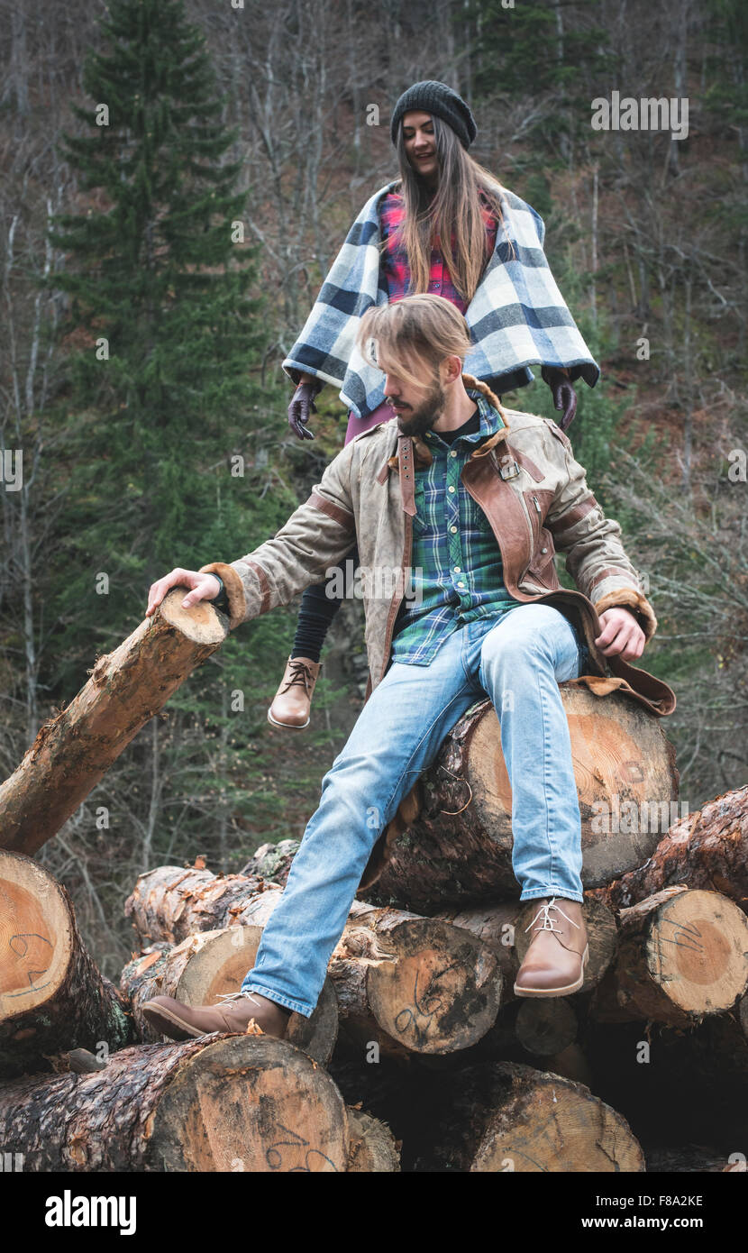 Young woman and men on wood logs in the forest Stock Photo - Alamy