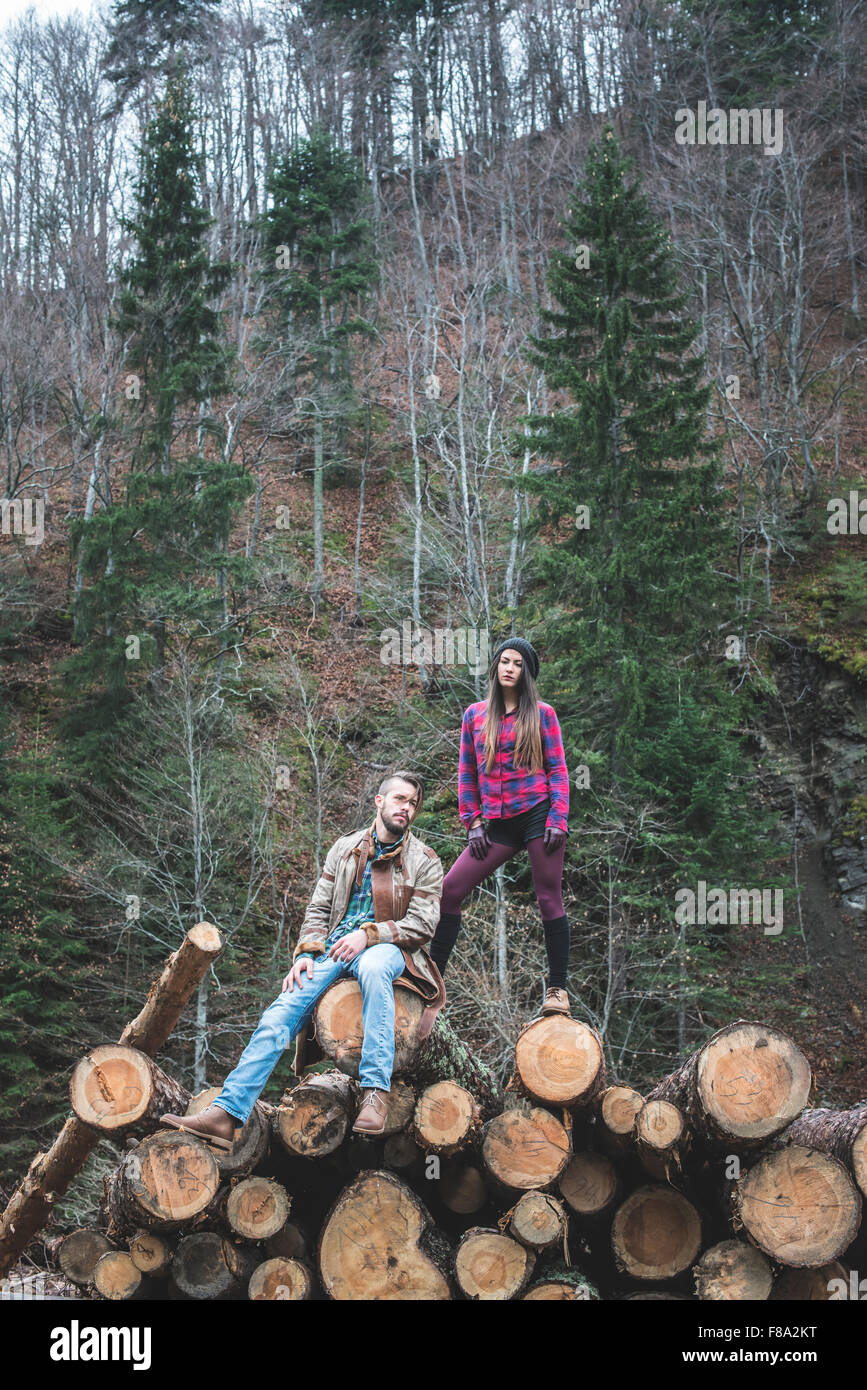 Young woman and men on wood logs in the forest Stock Photo - Alamy