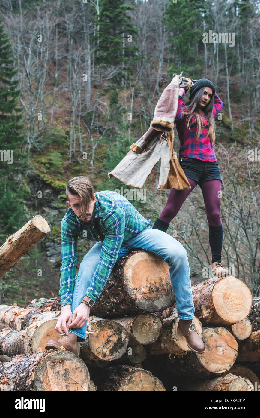 Young woman and men on wood logs in the forest Stock Photo - Alamy