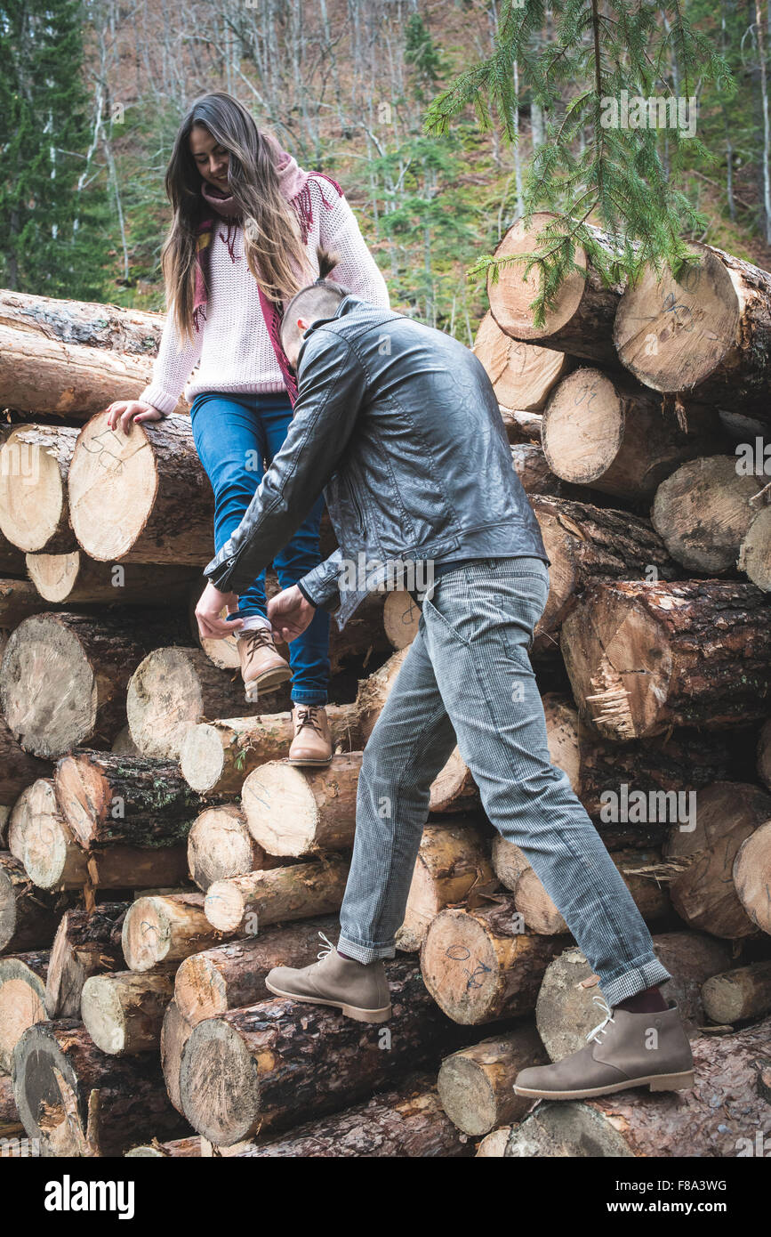 Young woman and men on wood logs in the forest Stock Photo - Alamy