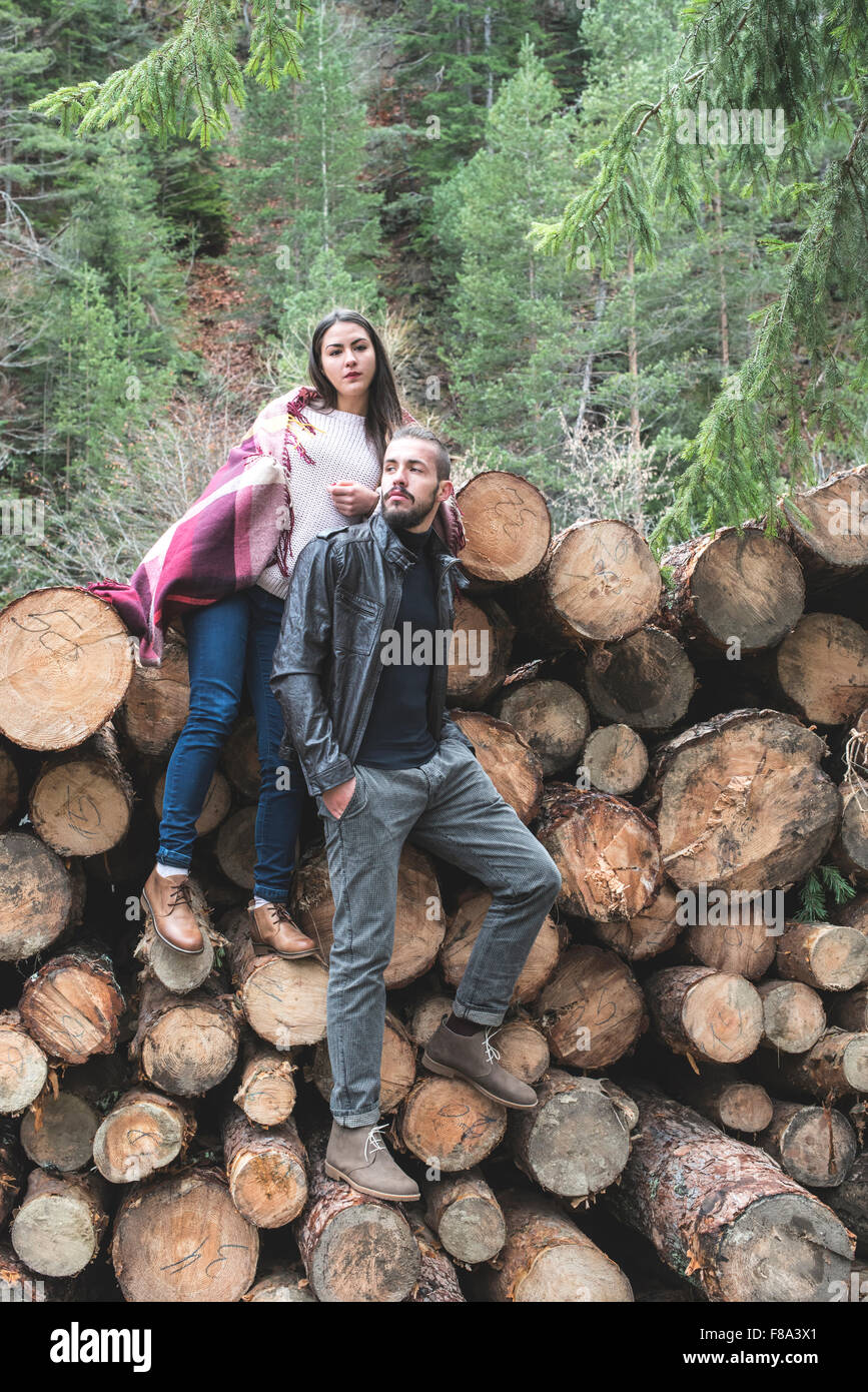 Young woman and men on wood logs in the forest Stock Photo - Alamy