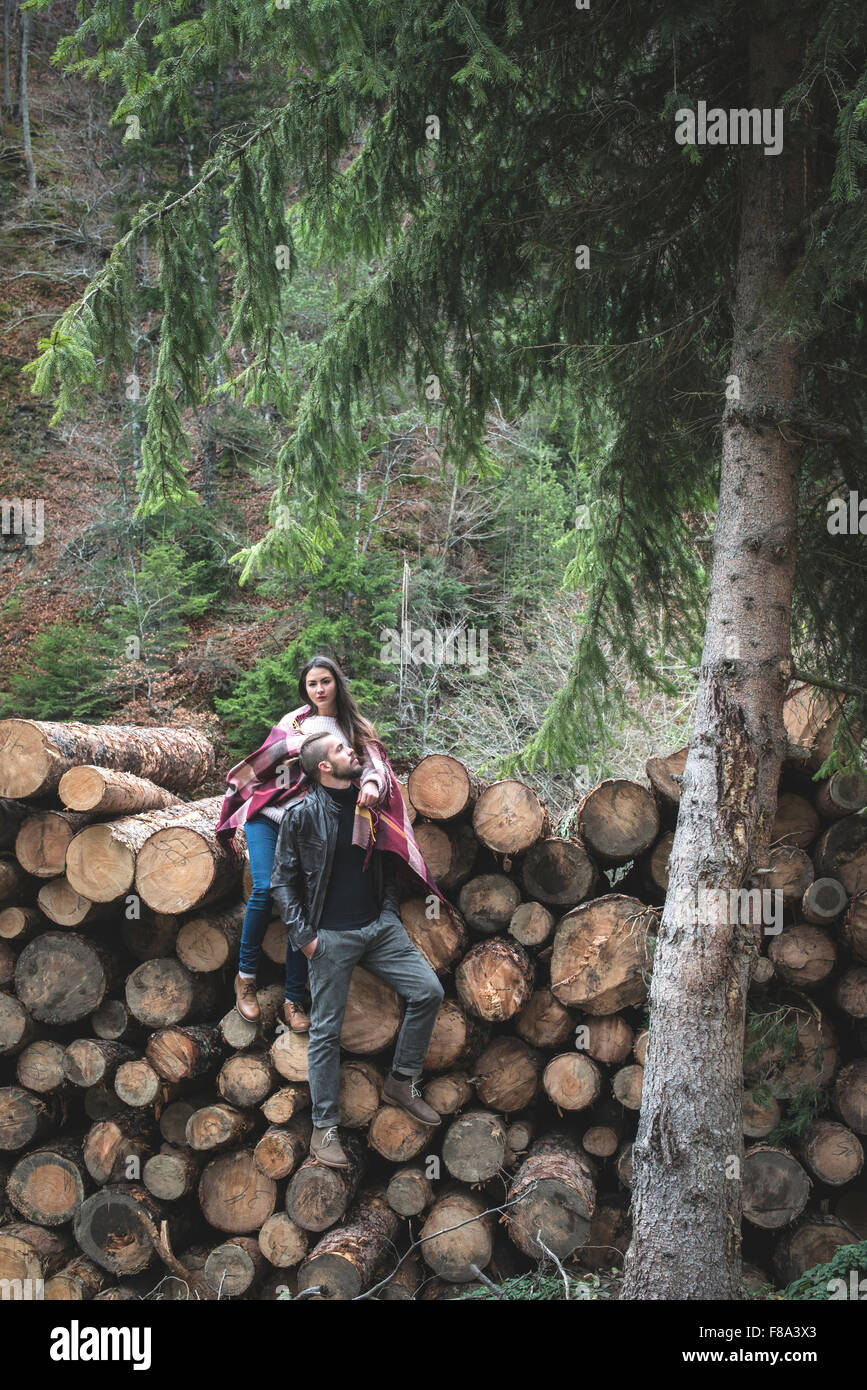 Young woman and men on wood logs in the forest Stock Photo - Alamy