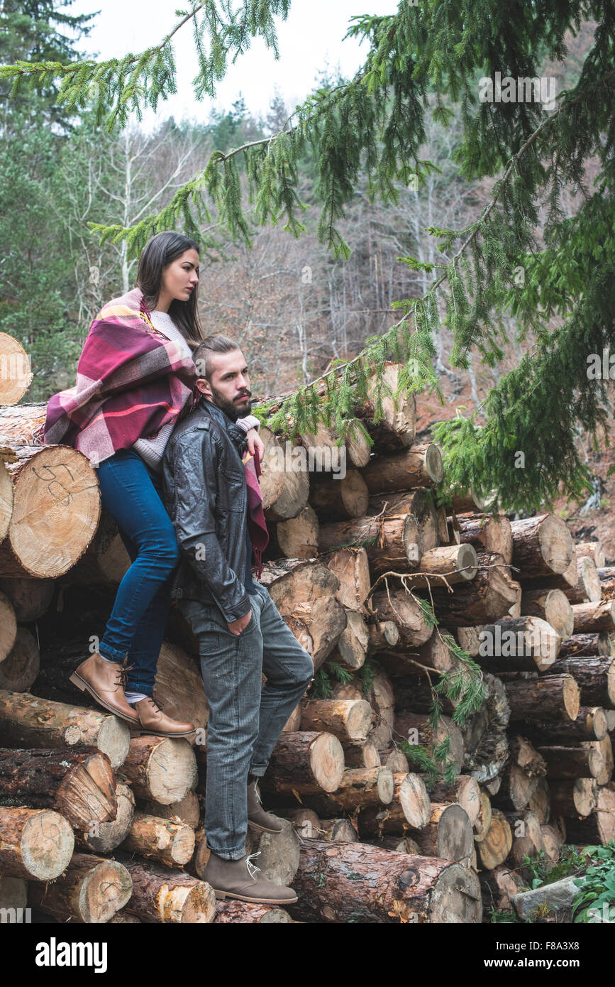 Young woman and men on wood logs in the forest Stock Photo - Alamy