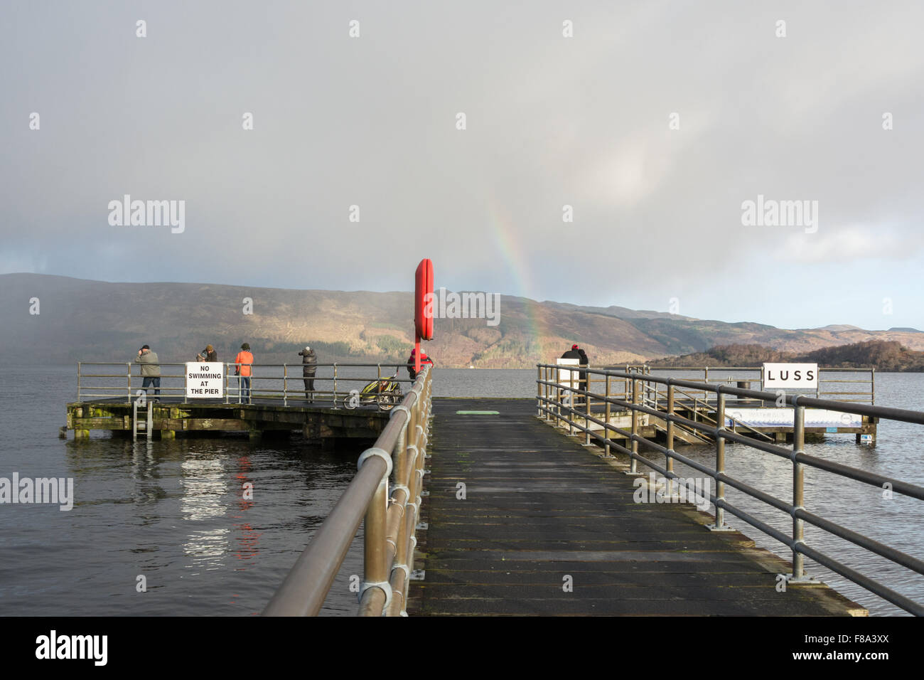 High water and rainbow at Luss Pier, Loch Lomond after unusually heavy rains Stock Photo