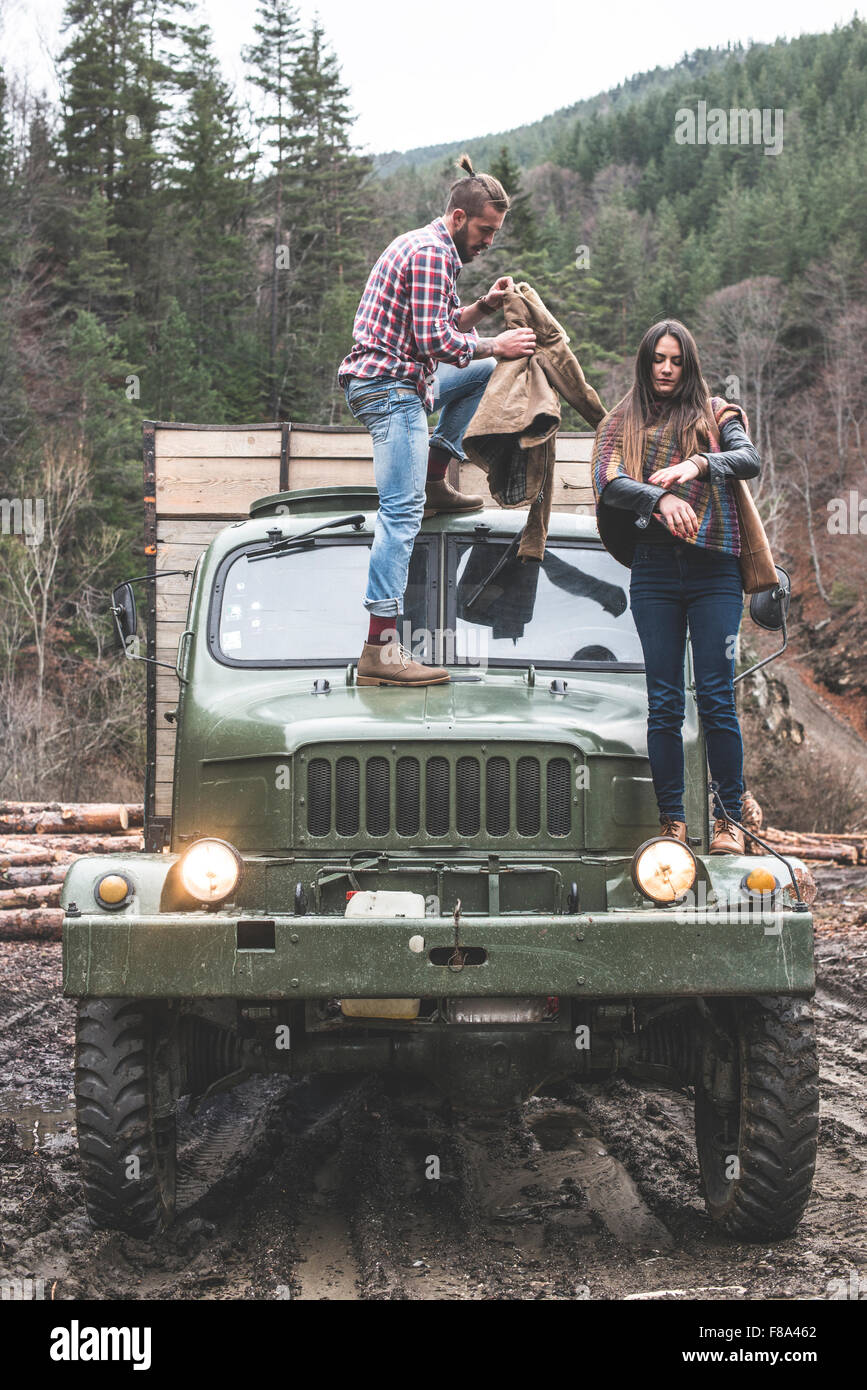 Young man and girl on truck with logs in the forest Stock Photo - Alamy
