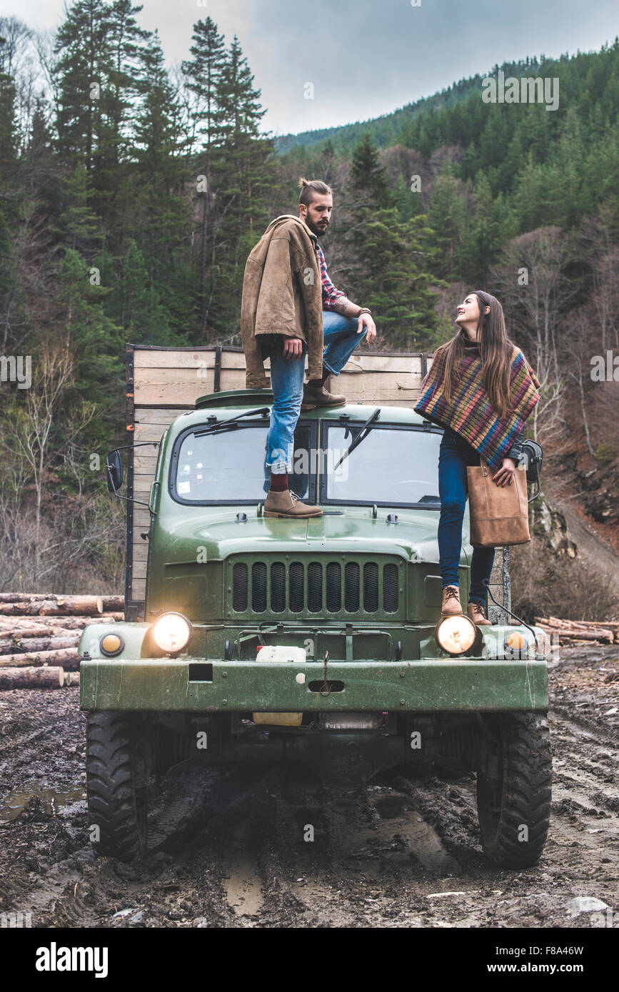 Young man and girl on truck with logs in the forest Stock Photo - Alamy