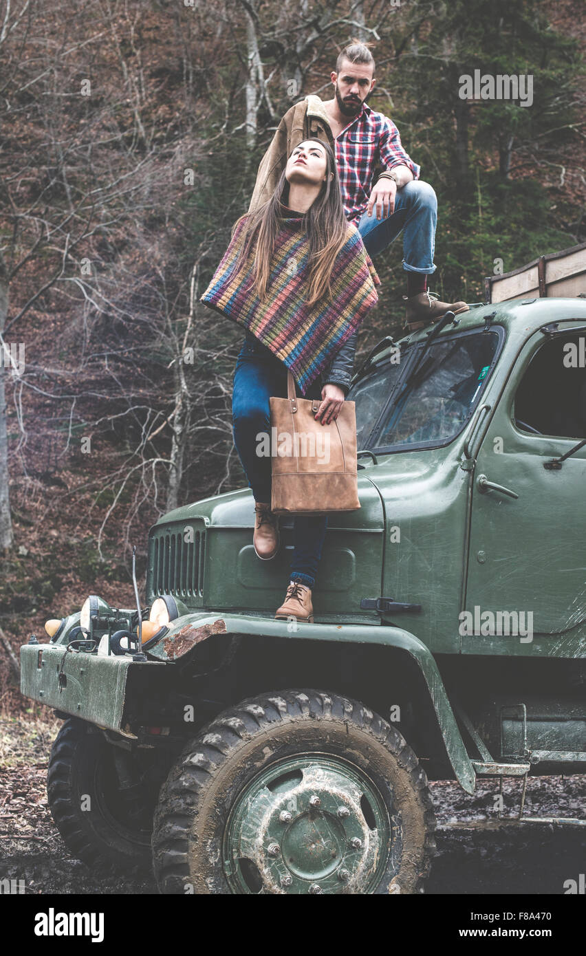Young man and girl on truck with logs in the forest Stock Photo - Alamy