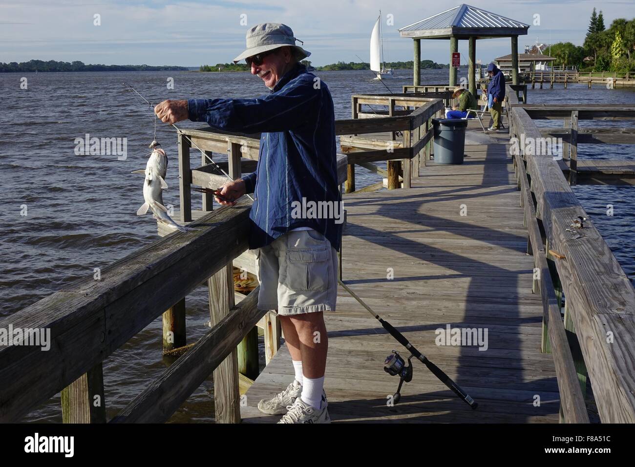 Fisherman bringing in a large catfish at the fishing dock in