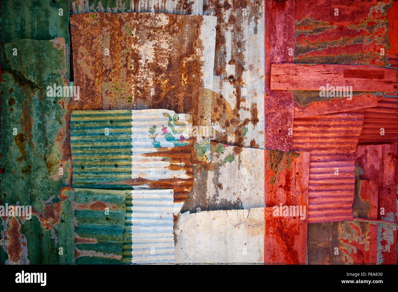 An abstract background image of the flag of Mexico painted on to rusty corrugated iron sheets overlapping to form a wall Stock Photo