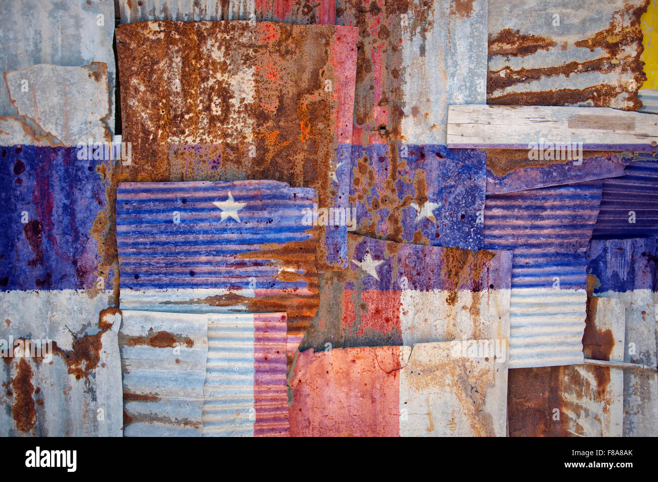 An abstract background image of the flag of Netherlands Antilles painted on to rusty corrugated iron sheets overlapping to form Stock Photo