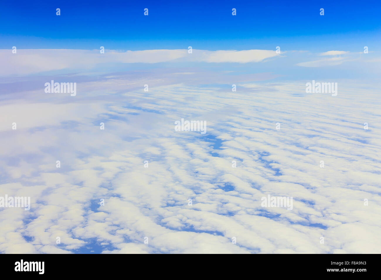 View on blue sky above white clouds from the window of airplane Stock ...