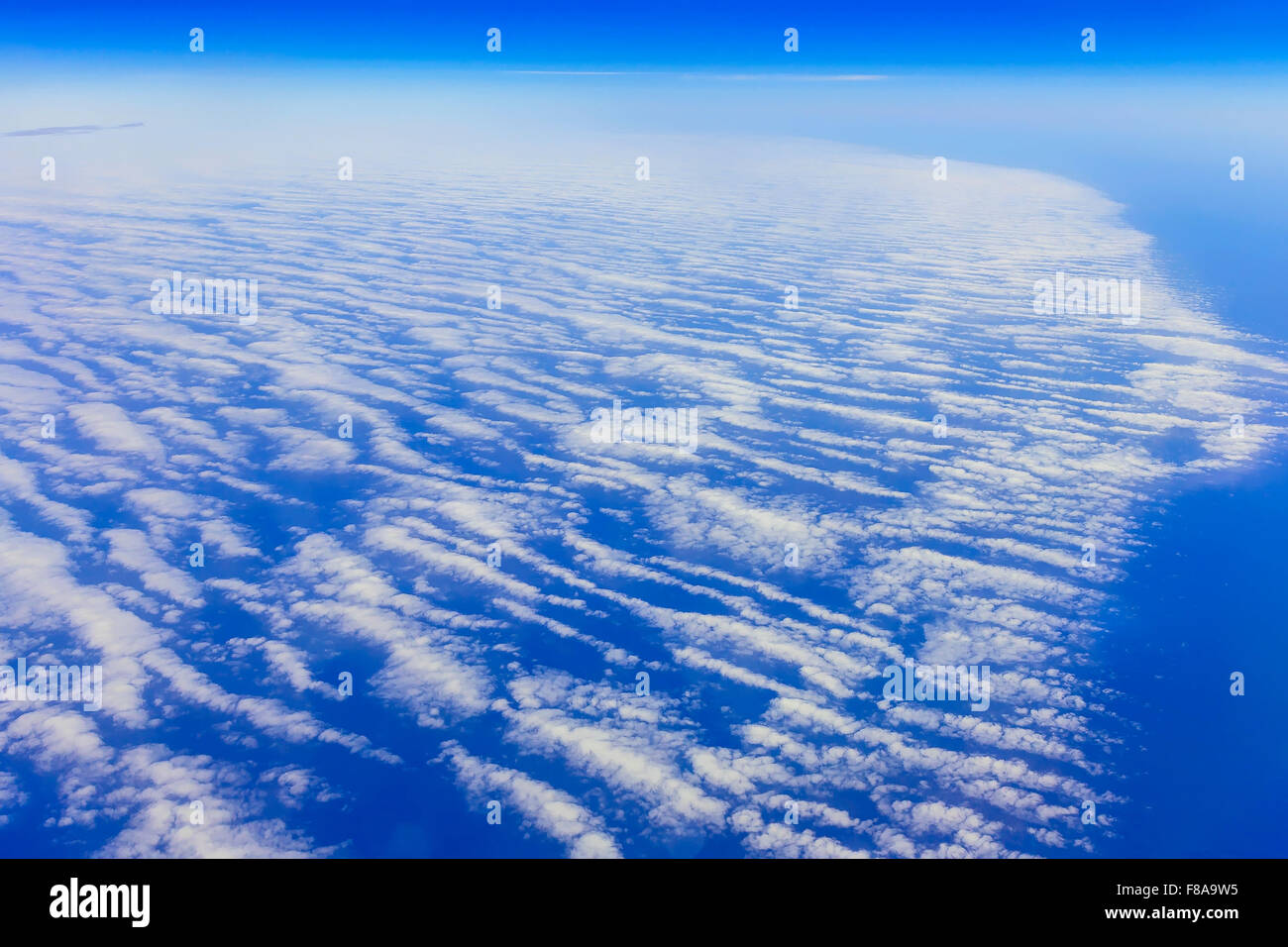 View on blue sky above white clouds from the window of airplane with ...