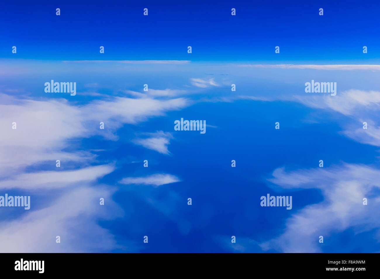 View on blue sky above white clouds from the window of plane with ...