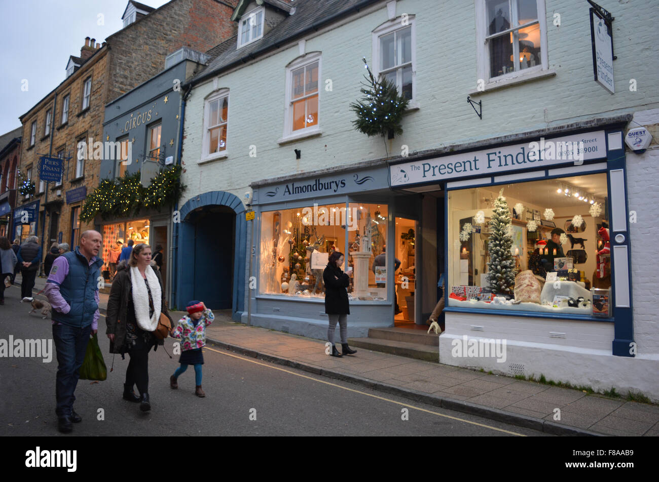 Family walking past shops decorated for Christmas in Cheap Street
