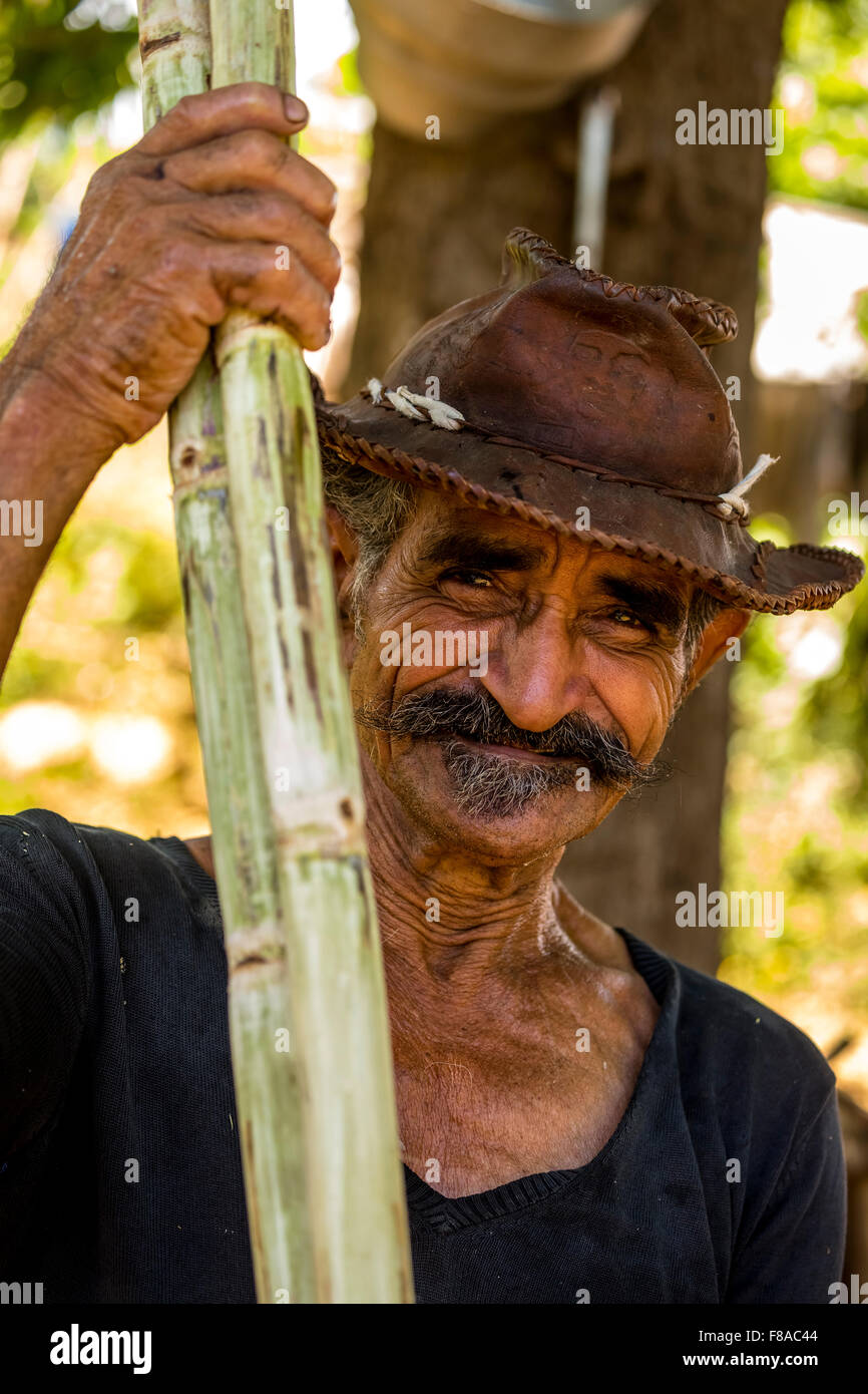 Sugarcane farmers in the Valle de los Ingenios, with a sugarcane, Portrait with Hat, Trinidad, Sancti Spíritus, Cuba, Stock Photo