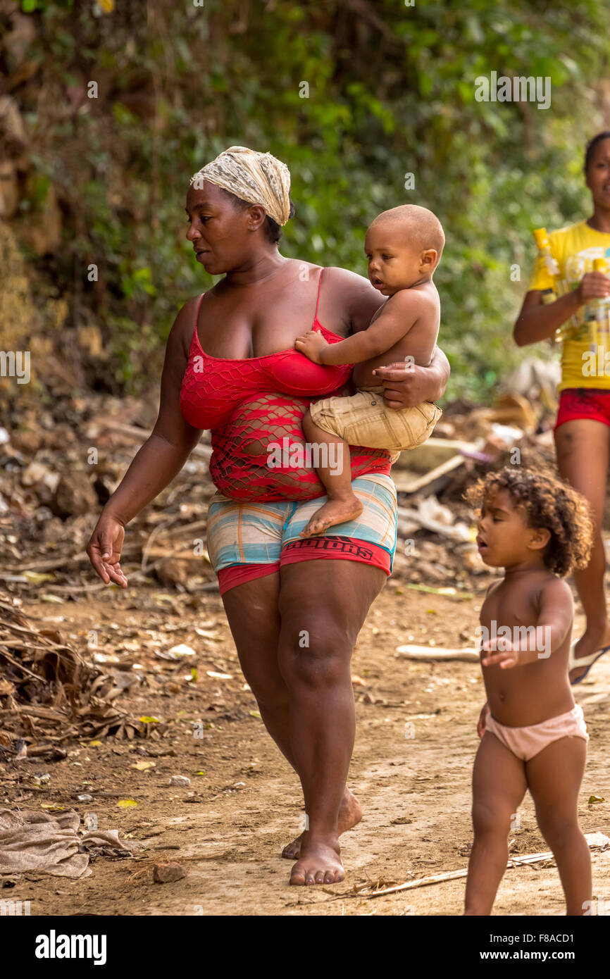 Mother with two children walking barefoot on a garbage dump, poverty on the island of Cuba, Street Scene, Trinidad, pavement, Stock Photo