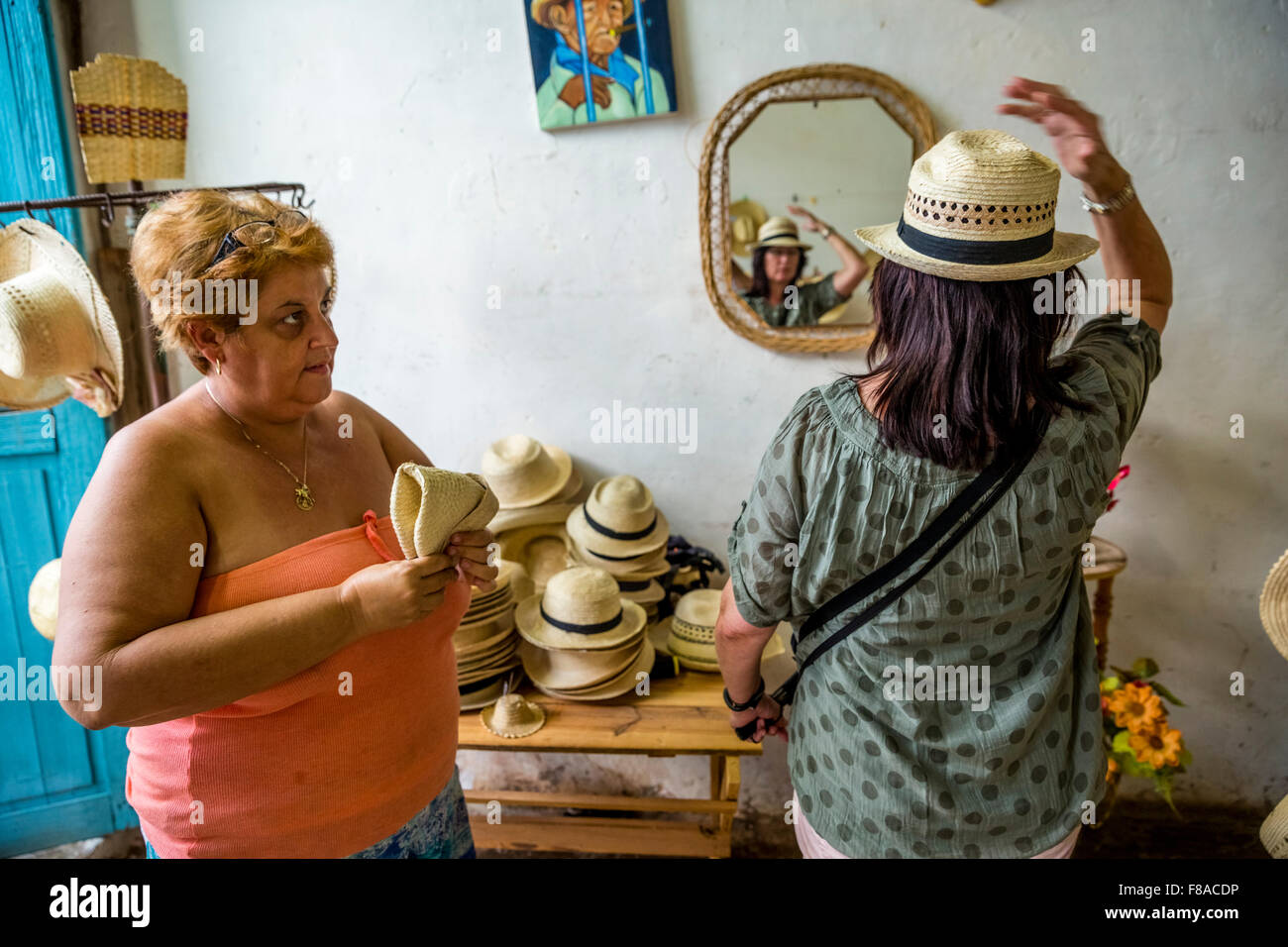 Cuban Hat saleswoman with a tourist in a shop in the old town of Trinidad, Street scene in the old town of Trinidad, Trinidad, Stock Photo