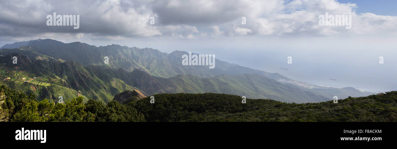 mountain landscape panoramic view - green forest, blue sky and ocean background Stock Photo