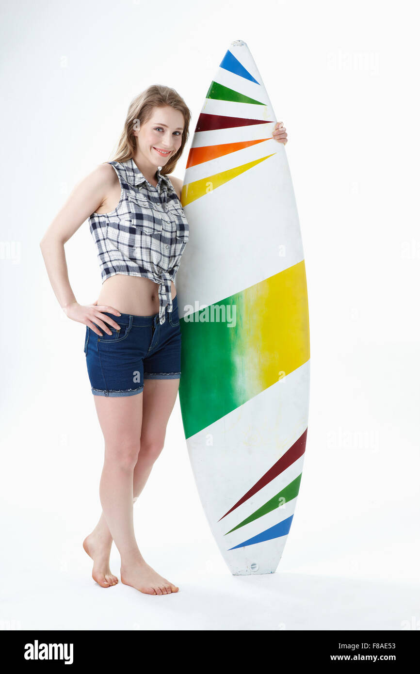 Smiling lady with holding a surfing board Stock Photo